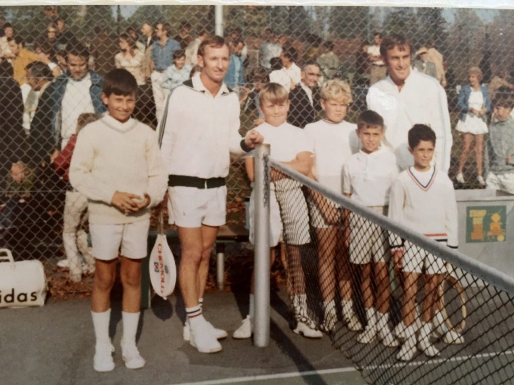 Rod Laver et John Newcombe posant pour une photo avec des enfants sur un court de tennis en Colombie-Britannique