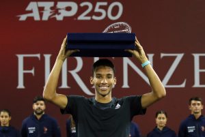 Felix Auger-Aliassime holds the Florence trophy above his head.